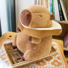 Plush toy resembling a capybara with a plush toast on a wooden surface