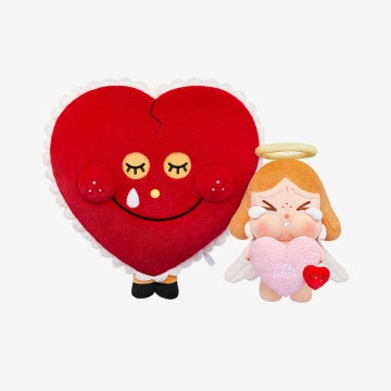 Heart-shaped plush toy with a face and an angelic figure holding a heart.