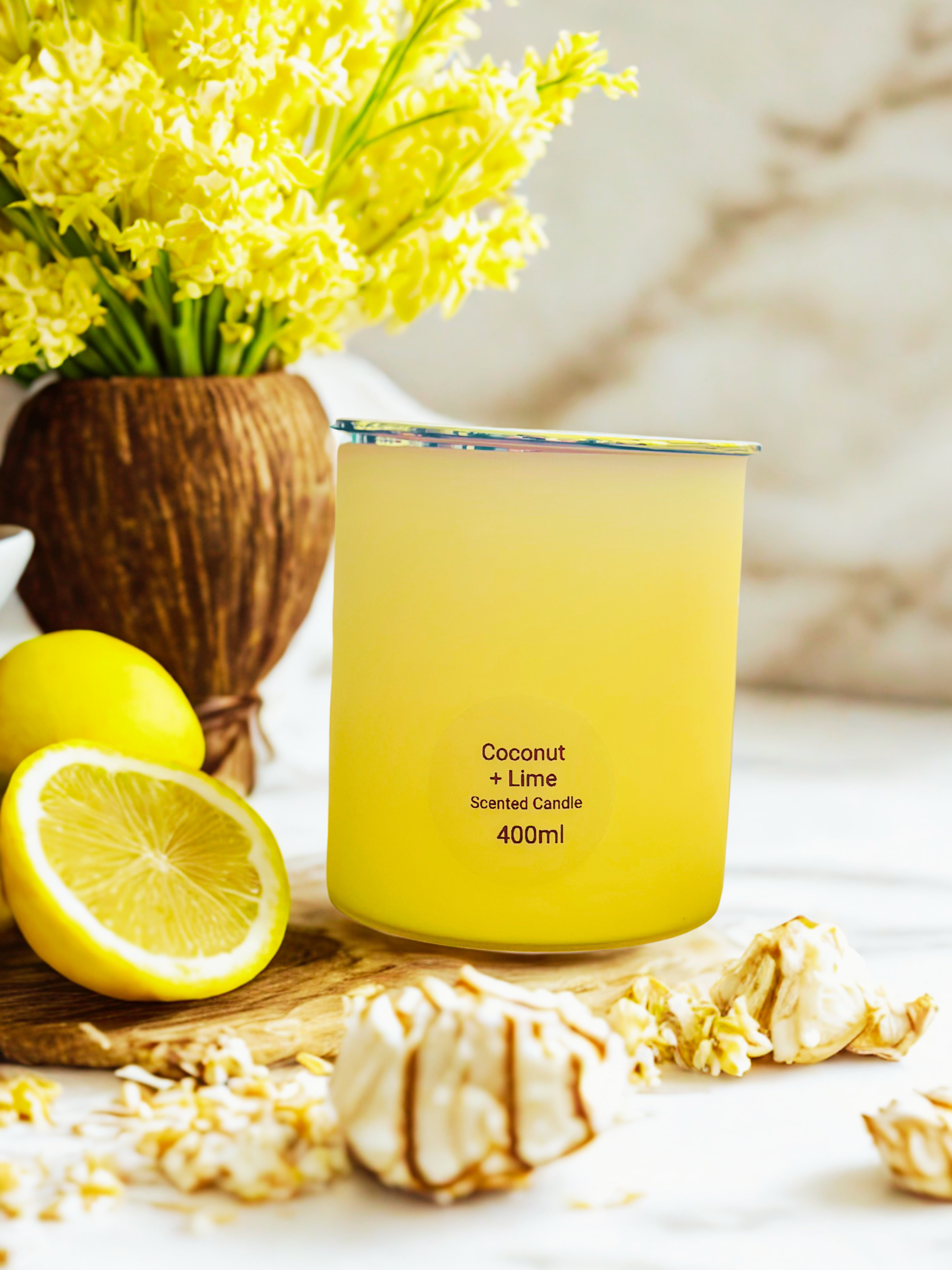 Lemon coloured scented candle with a tropical background.