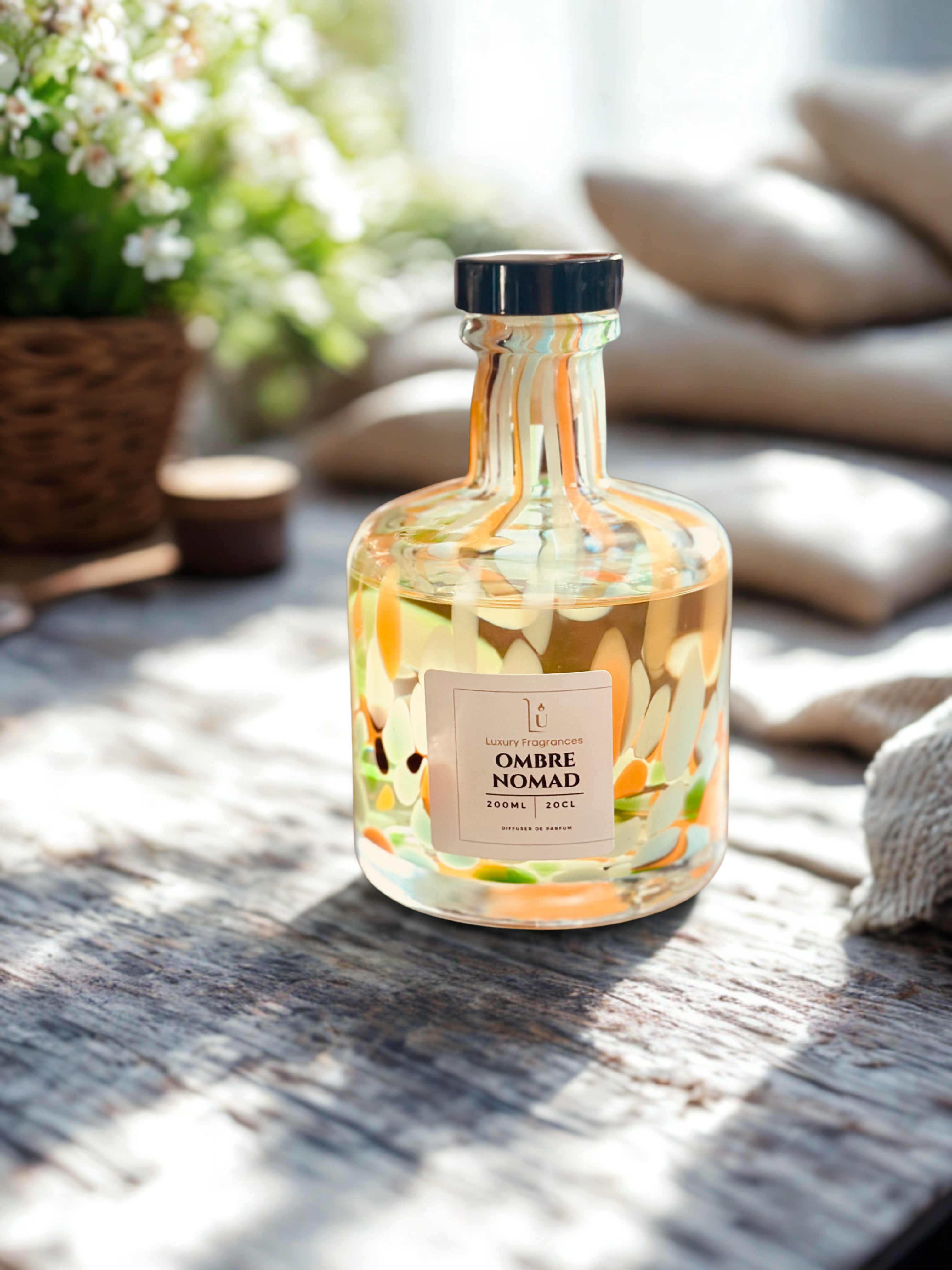 colourful bottle saying ombré nomad on the label surrounded with a plant and pillows.
