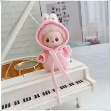 Plush toy with a pink outfit on a miniature piano