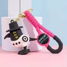 Keychain with cartoon character and pink handle on a light blue background