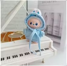Toy figure with Blue hoodie on a white piano