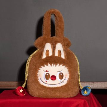 Brown plush bag with a face design on a red surface