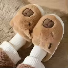 Pair of brown and white dog toys with plush ears on a soft surface