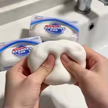 Hands squeezing white ASMR crunchy soap ball squishy stress toy