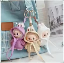 Three plush keychains shaped like cartoon characters on a white surface.