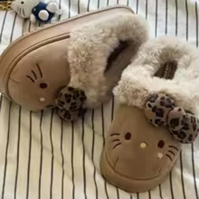 Pair of tan slippers with fluffy interior and cartoon face design on a striped background