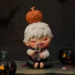 Small figurine with white hair and a pumpkin on its head, surrounded by Halloween-themed decorations.