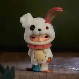 Toy figure of a white creature with bunny ears on a wooden surface