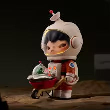 Figurine of a child in an astronaut suit holding a toy on a dark background