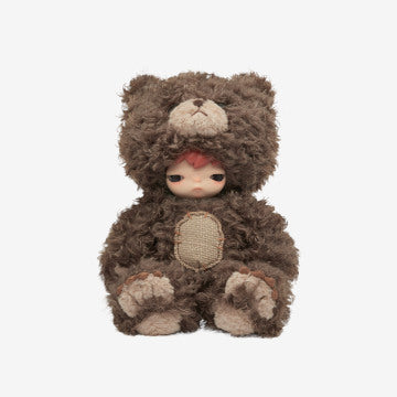 Small doll in a brown bear costume on a white background