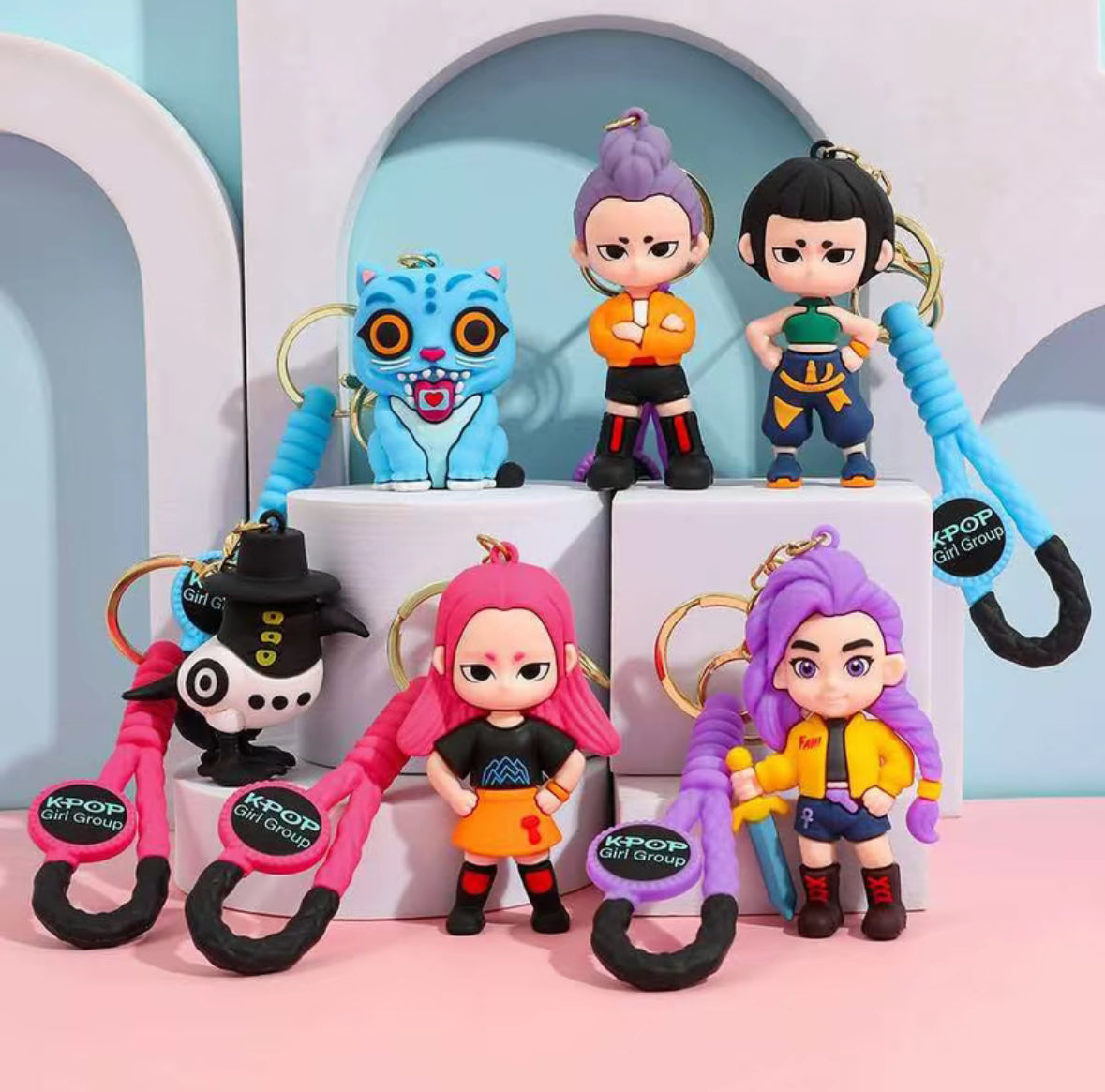 Keychains with character designs on a pink and blue background