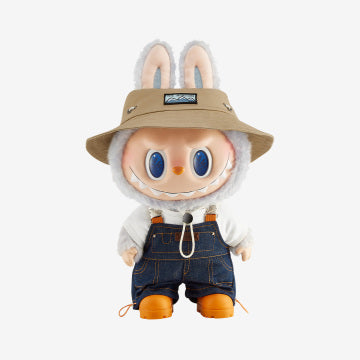  Embracing a "wild" theme, this figure stands nearly 16 inches tall and is dressed in denim overalls layered over a white t-shirt. It is accessorised with work boots and a brown bucket hat featuring "The Monsters" emblem. 