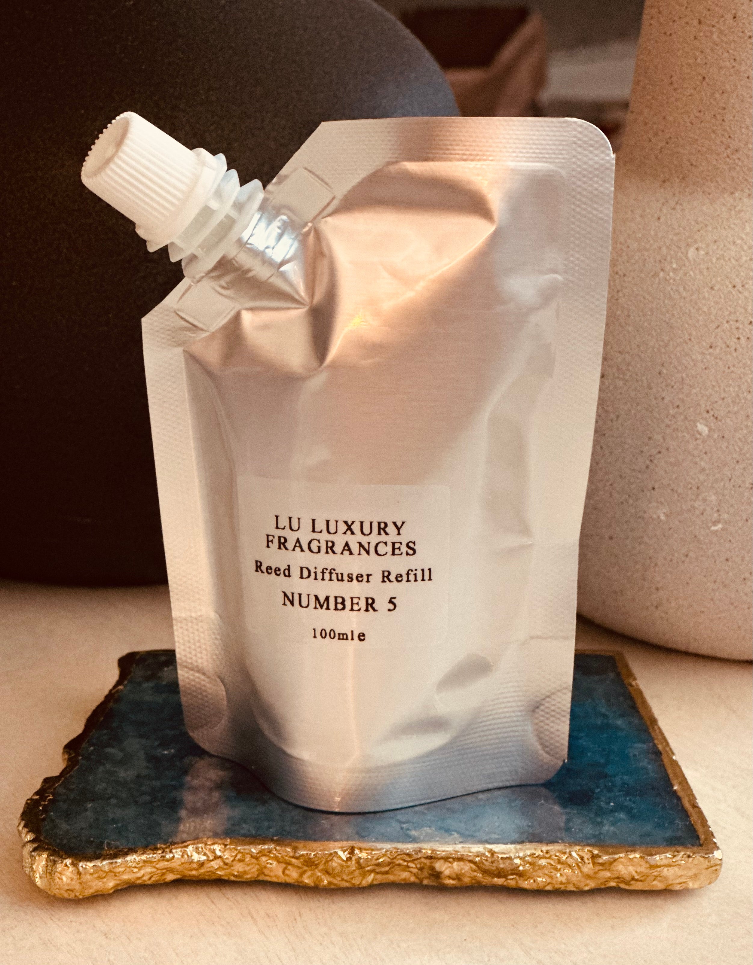 Silver liquid pouch on a  blue marble tile