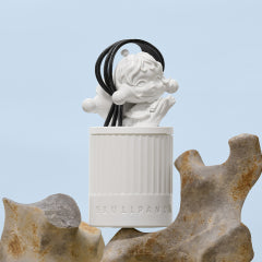 Decorative Pop Mart candle with a white base and black cord on a light blue background